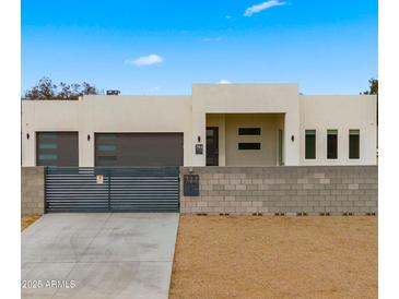 Modern stucco home with two-car garage and gated entry at 744 E Desert Ln, Phoenix, AZ 85042