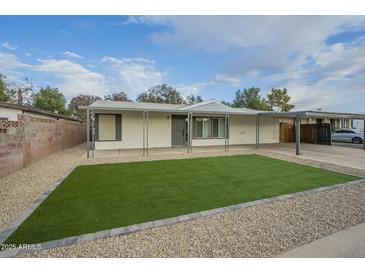 Updated single-level home with artificial turf lawn and covered carport at 9144 E Balsam Ave, Mesa, AZ 85208