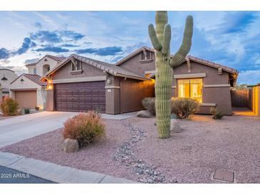 Desert landscape surrounds this one-story home with a two-car garage at 10512 E Dutchmans Trl, Gold Canyon, AZ 85118