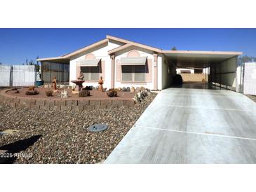 Single-wide manufactured home with carport and landscaped front yard at 106 S 72Nd Way, Mesa, AZ 85208