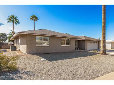 Single-story home with a two-car garage and desert landscaping at 11009 W Crestbrook Dr, Sun City, AZ 85351