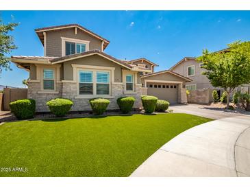 Two-story house with stone accents and a landscaped lawn at 13713 W Harvest Ave, Litchfield Park, AZ 85340