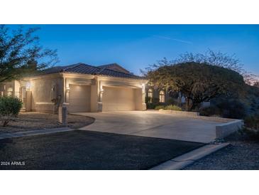 Attractive home exterior at dusk, showcasing a two-car garage and well-lit driveway at 14845 S 31St Way, Phoenix, AZ 85048