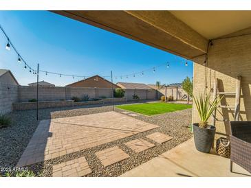 Charming backyard with paved patio, artificial turf, and string lights at 1537 E Caballero Dr, Casa Grande, AZ 85122