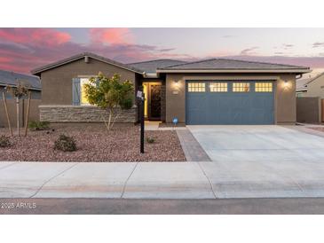 Single-story home with gray garage doors and stone accents at 35350 W Marin Ave, Maricopa, AZ 85138