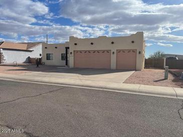 Tan three-car garage home with desert landscaping at 355 E 13Th Ave, Apache Junction, AZ 85119