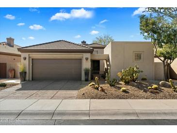 Single-story home with desert landscaping and a two-car garage at 6963 E Bramble Berry Ln, Scottsdale, AZ 85266