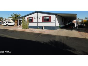 Mobile home with desert landscaping and golf cart at 8600 E Broadway Rd # 43, Mesa, AZ 85208