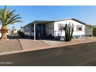 Mobile home with covered carport and desert landscaping at 8600 E Broadway Rd # 43, Mesa, AZ 85208