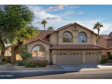 Two-story house with arched windows, tile roof, and landscaped front yard at 9077 E Camino Del Santo --, Scottsdale, AZ 85260