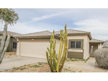 House exterior featuring a tan stucco finish and cacti at 13558 W Saguaro Ln, Surprise, AZ 85374
