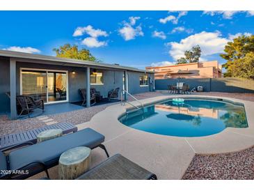 Inviting backyard oasis featuring a sparkling pool, patio, and relaxing lounge area at 13801 N 57Th St, Scottsdale, AZ 85254