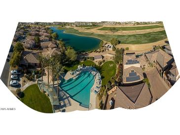 Aerial view of a community with a pool, golf course, and lake at 13612 W Cypress St, Goodyear, AZ 85395