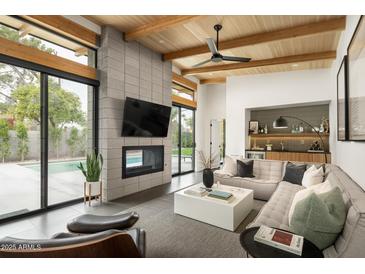 Open living space with fireplace, pool view, and comfortable seating at 1442 E Rancho Dr, Phoenix, AZ 85014