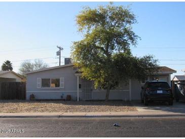 Ranch-style house with a carport and mature tree in front at 14846 N 29Th Ave, Phoenix, AZ 85053