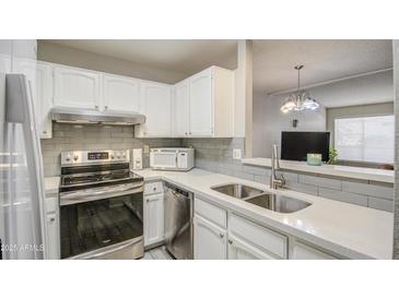 Kitchen with white cabinets, stainless steel appliances, and a double sink at 4608 W Maryland Ave # 127, Glendale, AZ 85301