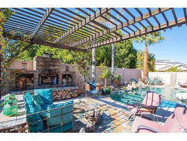 Relaxing pool area with a pergola and fireplace at 758 S Lagoon Dr, Gilbert, AZ 85233