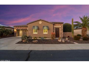 Beautiful desert home exterior at sunset; stone accents and landscaped yard at 13036 W Fetlock Trl, Peoria, AZ 85383