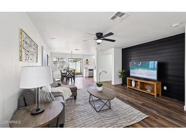 Bright living room with hardwood floors, comfy seating, and a modern aesthetic at 17452 W Ventura St, Surprise, AZ 85388