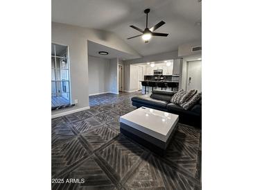 Bright living room with wood-look tile flooring, modern ceiling fan, and updated kitchen view at 200 E Southern Ave # 242, Tempe, AZ 85282