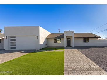 Modern single-story home with a two-car garage and landscaped lawn at 2129 S Los Feliz Dr, Tempe, AZ 85282