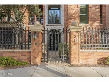 Brick building with ornate iron gate and landscaping at 30 W Palm Ln, Phoenix, AZ 85003