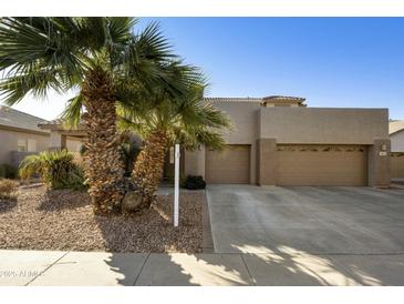 Charming home featuring desert landscaping, palm trees, and a spacious three-car driveway at 4615 W Corral Rd, Laveen, AZ 85339
