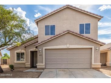 Two-story house with tan exterior, two-car garage, and landscaping at 6537 W Riva Rd, Phoenix, AZ 85043