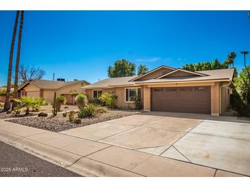 Inviting single-story home with a landscaped front yard and attached two-car garage at 1643 W Harmont Dr, Phoenix, AZ 85021