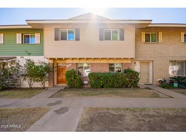 Cute condo with a well-manicured front yard and inviting wooden door at 1682 W Campbell Ave, Phoenix, AZ 85015