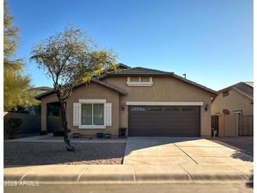 Tan house with brown garage door and landscaping at 1933 S Peppertree Dr, Gilbert, AZ 85295