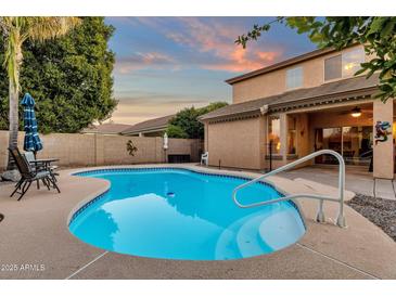 Inviting kidney-shaped pool with patio furniture, ready for summer fun at 3436 E Vaughn Ave, Gilbert, AZ 85234