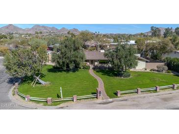 Aerial view of a charming home with a well-manicured front lawn and mature trees at 4022 E Stanford Dr, Phoenix, AZ 85018