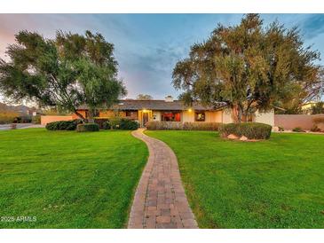 Charming home featuring a brick pathway leading through a lush green lawn to the inviting entrance at 4022 E Stanford Dr, Phoenix, AZ 85018