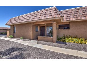 Tan stucco condo building with a tile roof and walkway at 409 W Pontiac Dr # 8, Phoenix, AZ 85027