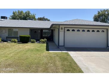 Ranch-style home with a two-car garage and well-maintained lawn at 4829 E Lake Point Cir, Phoenix, AZ 85044