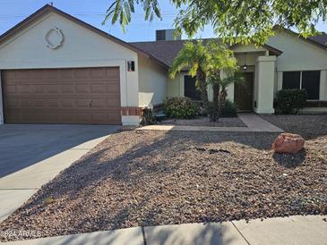 Single-story home with brown garage door, landscaping, and rockery at 620 S Laveen Dr, Chandler, AZ 85226