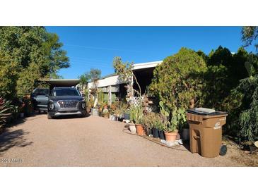 Mobile home exterior with landscaping, driveway, and vehicle at 8120 E Boise St, Mesa, AZ 85207