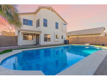 Inviting backyard oasis with a sparkling pool, spacious patio, and lush landscaping at 9336 E Obispo Ave, Mesa, AZ 85212