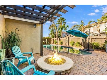 Relaxing backyard oasis with a fire pit, pool, pergola, and lounge chairs for outdoor enjoyment at 18456 E Superstition Dr, Queen Creek, AZ 85142
