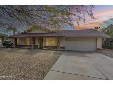 Charming single-story home features a low-maintenance gravel yard and a two-car attached garage at 4453 W Keating Cir, Glendale, AZ 85308