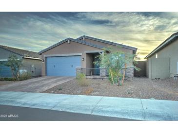 Single-story home with a two-car garage and landscaped front yard at 19945 W Badgett Ln, Litchfield Park, AZ 85340