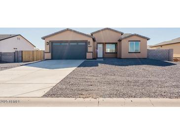 New construction home with a two-car garage and desert landscaping at 12503 W Jenero Dr, Arizona City, AZ 85123