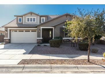 Two-story house with a beige exterior, a three-car garage, and landscaping at 22235 E Munoz Ct, Queen Creek, AZ 85142