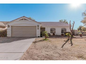 Single-story home with a two-car garage and well-maintained landscaping at 9041 W Virginia Ave, Phoenix, AZ 85037