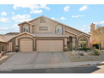 Inviting two-story home featuring a three-car garage and desert landscaping at 2249 E Taxidea Way, Phoenix, AZ 85048