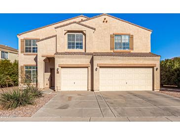 Two-story house with beige exterior, two-car garage, and landscaping at 35834 W Cartegna Ln, Maricopa, AZ 85138