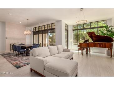 Bright, open living room with grand piano, modern lighting, and comfortable seating area at 8 E Biltmore Est # 117, Phoenix, AZ 85016