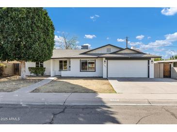 Charming single-story home featuring a well-maintained front yard and a two-car garage at 1521 E Del Rio Dr, Tempe, AZ 85282