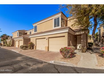 Tan two-story townhome with two-car garage and landscaping at 7887 N 16Th St # 224, Phoenix, AZ 85020